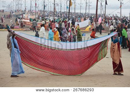 ALLAHABAD, UTTAR PRADESH, INDIA - FEBRUARY 07, 2013: Women put their sari out to dry on wind after ritual holy bathing in the Ganges river during the festival Kumbh Mela
