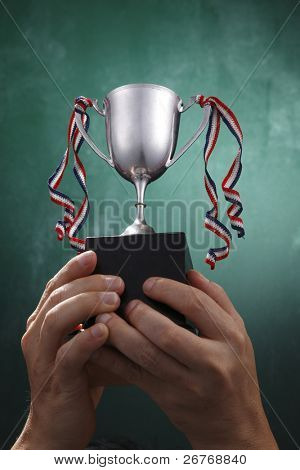 人間の手は、銀のトロフィーを保持します。