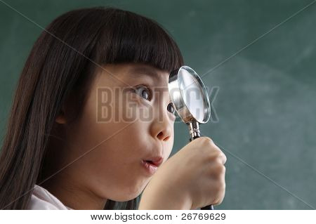close up of Child holding eine Lupe