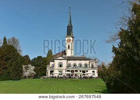 People Resting In The Villette-park On The Shore Of Lake Zug. View Of The Villa-villette And Saint J