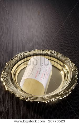 Lager Bild von geschweiften Belehrung auf dem goldenen Teller