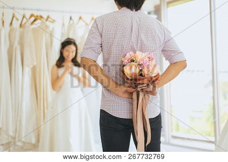 Groom Hiding Flower Behind Back In Order To Surprise Bride,woman Positive Emotion And Face Astonishe