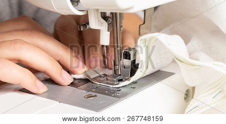 Close-up Of Sewing Machine Being Used For Sitching White Fabric