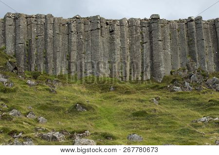 Wall Of High Basalt Columns In Iceland. Volcanic Basalt Coloumn Formations.