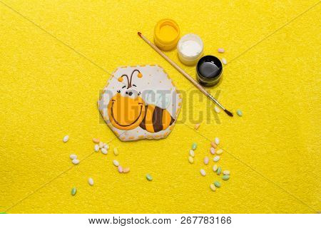 Gingerbread Bee On Yellow Background With Paints Near It