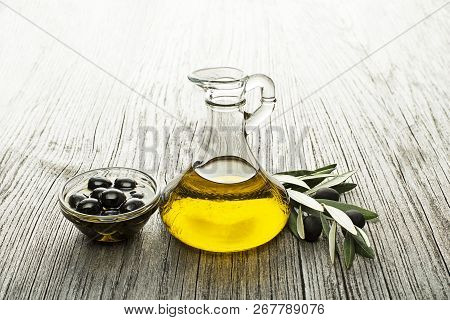 Bottle Of Extra Virgin Healthy Olive Oil With Fresh Black Olives Close Up