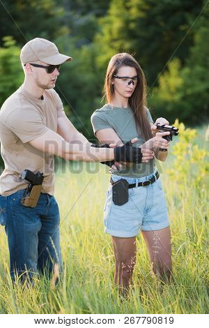 The Instructor Teaches The Girl To Shoot A Pistol At The Range