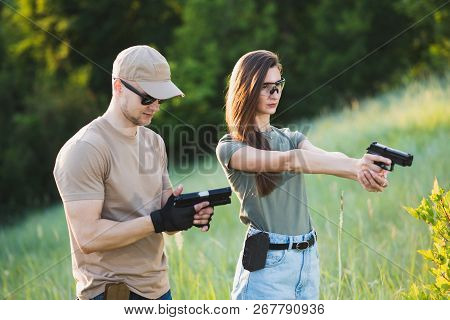 The Instructor Teaches The Girl To Shoot A Pistol At The Range