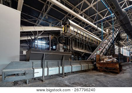 Conveyor Belt At Recycling Plant Transports Garbage Inside Drum Filter Or Rotating Cylindrical Sieve