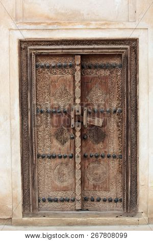 Carved wooden door and ornate doorway in a courtyard of traditional Arabian house of pearl trader Shaikh Isa bin Ali, Muharraq, Bahrain