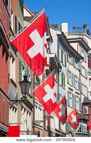 Gamle gade Augustinergasse i Zürich dekoreret med schweiziske flag