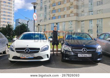 MOSCOW - JUN 20, 2018: Sporty man (with MR) and two Mercedes Benz cars of Moscow carsharing company You drive, carsharing is system of short-term car rental