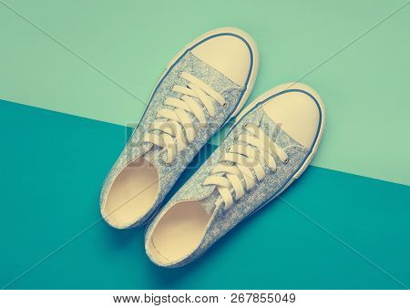 Fashionable Women's Sneakers With White Laces From The 80S On A Blue Pastel Background. Top View.