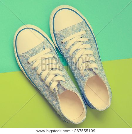 Fashionable Women's Sneakers With White Laces From The 80S On A Green Blue Paper Background. Top Vie