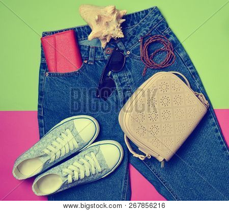 Women's Accessories Lie On Classic Jeans With An Overstated Waist. Sneakers, Purse, Bag, Belt On A P