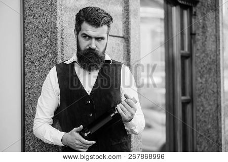 Man Holding Bottle Of Wine. Brutal Hipster With Long Beard And Moustache On Serious Face Outdoors On