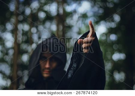 The Black Monk Pointing His Finger In The Woods