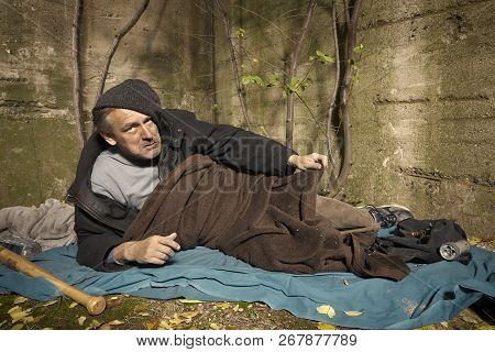 Ugly Pauper Man Living Outdoor Sleeping, Relaxing And Laying Alone On Hidden Urban Place