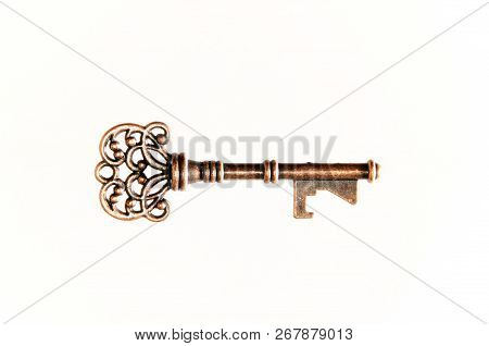 Side View Of Ornate Brass Skeleton Key For Door Or Lock On White.