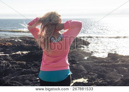 Beautiful Blond Woman Runs Her Hands Through Her Long Hair While Enjoying The Spectacular Sunset Dur