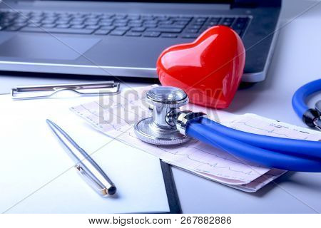 Workplace Of Doctor With Laptop, Stethoscope, Red Heart And Rx Prescription On White Table. Top View