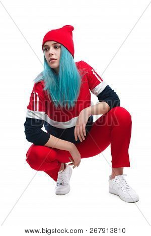 Trendy Serious And Confident Woman With Blue Dyed Hair Wearing Stylish Red Sportive Outfit And Sitti