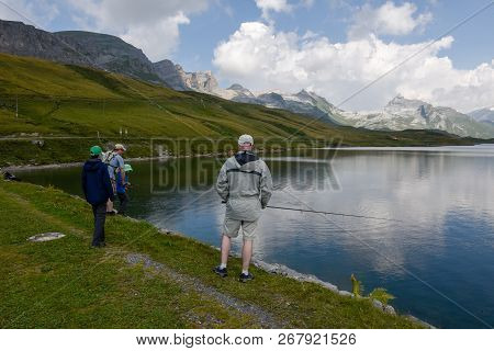 Father And Son Fishing Together At Lake Tannensee On Switzerland