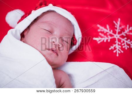 Newborn Baby Sleeping On Santa Het And Red Background,