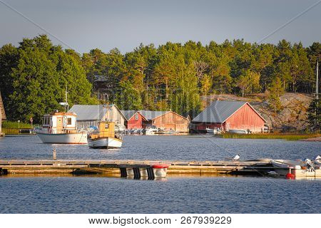 Wooden Boathouses At Sunset In Aland Archipelago, Where Nature Is Magnified