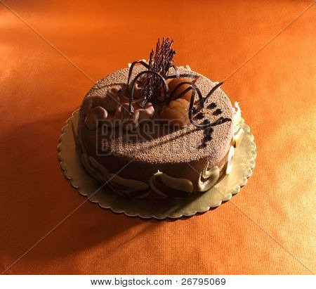 eine eingerichtete Kastanienkuchen auf orange hintergrund isoliert