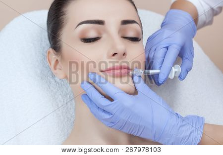 The Doctor Cosmetologist Makes Lip Augmentation Procedure Of A Beautiful Woman In A Beauty Salon.cos