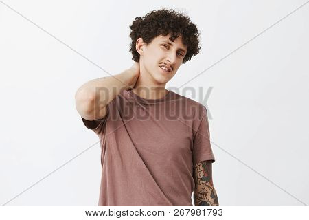 Waist-up Shot Of Unsure Handsome And Stylish Curly-haired Guy With Moustache Unwilling To Do Extra W