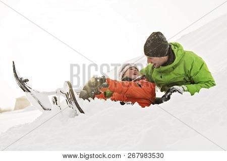 A Nice Father And Son Sitting On Sledge