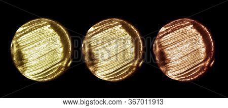 Creative brushstrokes of gold paint isolated on a black background. Gold paint texture.Acrylic gold paint. Smears of cosmetics, blush, highlighter, eye shadow, lipstick.