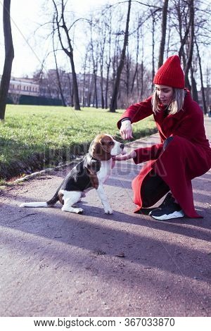 Pretty Young Girl In Redd Coat Playing With Dog Outside In Green Park, Lifestyle People Concept