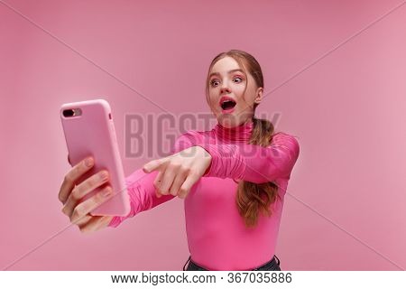 The Best Day Ever. Surpised Young Redhead Woman Holding Pink Smartphone, Smiling And Expressing Posi