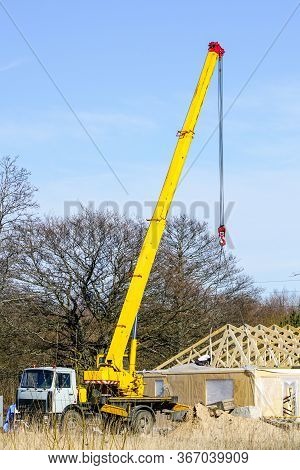 Truck Mounted Crane With A Telescoping Boom At Constructing A Carcas Of A New Wooden Building