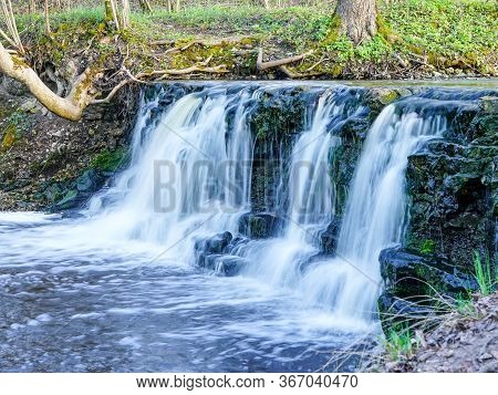Beautiful View In Spring Of A Waterfall In A Small River