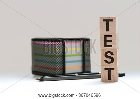Wooden Blocks Spell Out Test On A Blue Bubble Or Scantron Sheet With A Number Two Yellow Pencil.