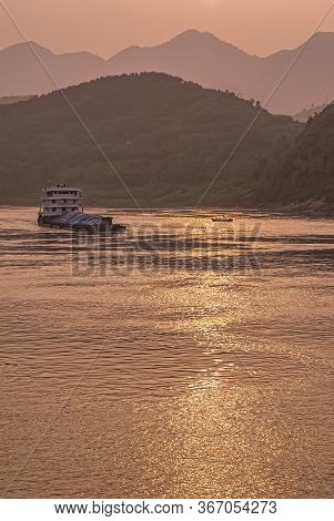 Chongqing, China - May 8, 2010: Evening Light On Yangtze River. Loaded Barge Sails On While Golden S