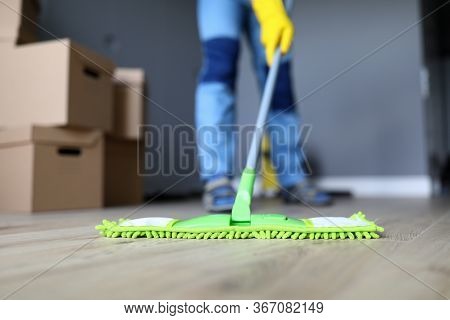 Close-up Of Male Hands Holding Microfiber Fluffy Rag And Mopping Floors. Cleaning Apartment After Mo