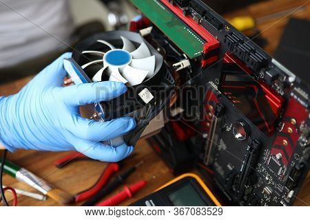 Close-up Of Middle-aged Man Repairing Detail Of Device. Technician Male Fixing Computer Mainboard. T