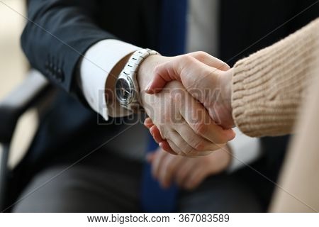 Close-up Of Business Partners Shaking Hands. Young Woman In Presentable Luxury Suit Holding Document
