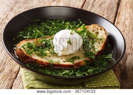 Tasty Portuguese Acorda Soup With Greens, Garlic, Bread And Poached Egg Close-up In A Plate. Horizon