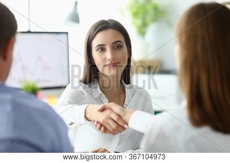 Portrait Of Joyful Businesswoman Sitting At Modern Workplace And Shaking Hand With Woman Partner. Bu