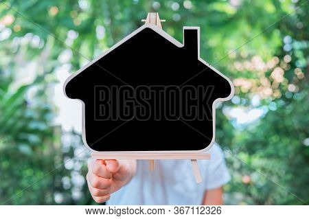 People Holding Wooden House With Copy Space For Text. New Normal And Life After Covid. Self-quaranti