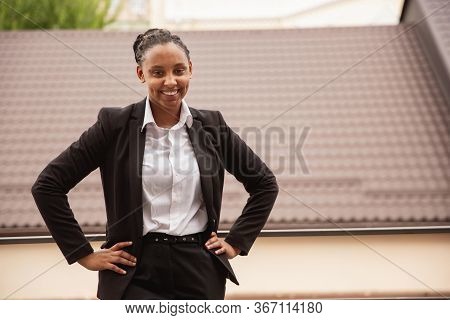 Confidence. African-american Businesswoman In Office Attire Smiling, Looks Confident And Happy, Busy