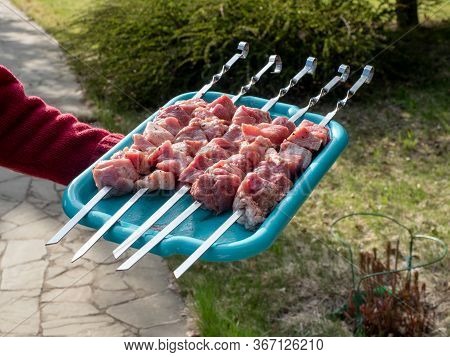 Raw Cubes Of Pork Meat On Metal Skewer.  Shashlik Or Shashlyk Preparing On A Barbecue Grill Over Cha