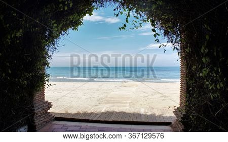 View Of The Mediterranean Sea Through An Arch Braided By Flowers