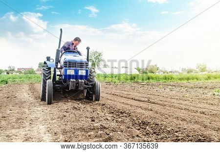 Farmer Is Processing Soil On A Tractor. Soil Milling, Crumbling Mixing. Loosening Surface, Cultivati